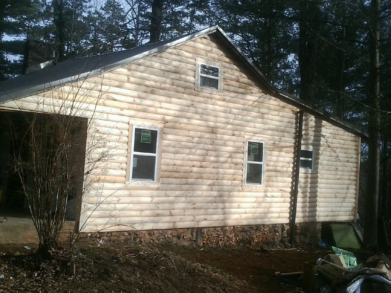 New log siding and dark metal roofing on a gable end in Sequim