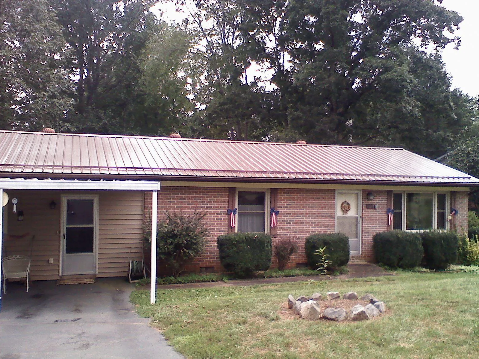 Bronze metal roof and carport on a brick ranch home — Roof Repair work by our crew in Sequim